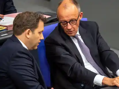 Bundeskanzler Friedrich Merz (CDU, r) spricht mit Lars Klingbeil (SPD), Bundesminister der Finanzen