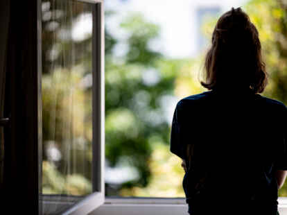 Eine Frau steht in ihrer Wohnung an einem Fenster. Psychische Erkrankungen sind oft unsichtbar – viele Betroffene ziehen sich zurück. Mit wohnortnahen Angeboten wie der geplanten Tagesstätte in Wiesmoor soll eine neue Perspektive geschaffen werden.