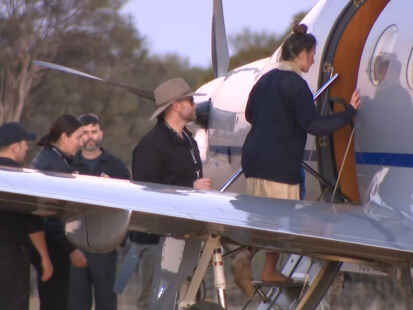 Ein Screenshot aus einem ABC-Fernsehvideo zeigt Carolina W. (r) beim Einsteigen in ein Flugzeug am Freitag, 11. Juli 2025. Eine deutsche Rucksacktouristin, die seit 12 Tagen in einem abgelegenen Buschland vermisst wurde, ist von Einsatzkräften lebend gefunden worden.