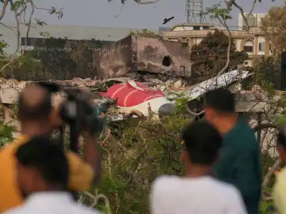 Menschen betrachten die Wrackteile des am Donnerstag (12.06.2025) abgestürzten Flugzeugs von Air India. (Foto Archiv)