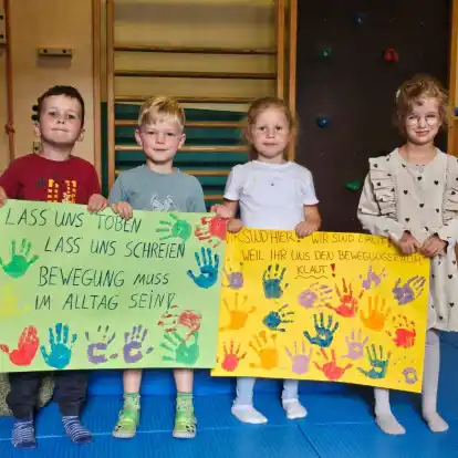 „Wir sind hier, wir sind laut, weil ihr uns den Bewegungsraum klaut“ - steht auf einem der zwei Plakate, die Kindergartenkinder mit ihren Eltern gebastelt haben und bringen den Unmut der Betroffenen zum Ausdruck.
