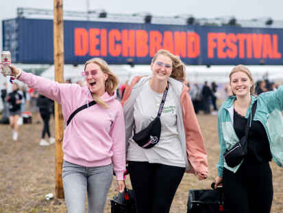 17.07.2025, Niedersachsen, Nordholz: Die Festivalbesucherinnen Anna (l-r), Ramona und Julia aus Hamburg gehen über das Festivalgelände des Deichbrand Festivals. Das Open-Air-Festival mit rund 60.000 Besuchern findet vom 17. bis zum 20. Juli statt.