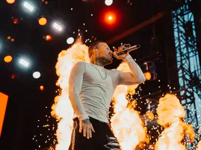 Kontra K fackelt auf der Deichbrand-Bühne eine Show ab: Der Rapper begeisterte am späten Freitagabend Zehntausende Festivalbesucherinnen und -besucher.