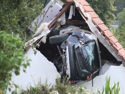 Ein Auto liegt nach einem kurzen Flug seitlich in der Mauer einer Scheune. Bei dem spektakulären Unfall im niedersächsischen Bohmte hat das Auto mit fünf Insassen zwei Hecken durchbrochen, ein Kind im Garten erfasst und sehr schwer verletzt. Danach ist da Auto in etwa drei Metern Höhe in dem Gebäude eingeschlagen und dort stecken geblieben.