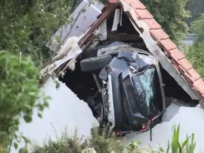 Ein Auto liegt nach einem kurzen Flug seitlich in der Mauer einer Scheune. Bei dem spektakulären Unfall im niedersächsischen Bohmte hat das Auto mit fünf Insassen zwei Hecken durchbrochen, ein Kind im Garten erfasst und sehr schwer verletzt. Danach ist da Auto in etwa drei Metern Höhe in dem Gebäude eingeschlagen und dort stecken geblieben.