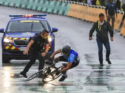 Ein Mann fährt bei der Tour de France unerlaubt über die Strecke.