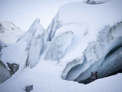 Ein Fotograf betritt eine Gletscherhöhle am Morteratschgletscher. Der Morteratschgletscher ist ein Alpen-Gletscher m Kanton Graubünden.