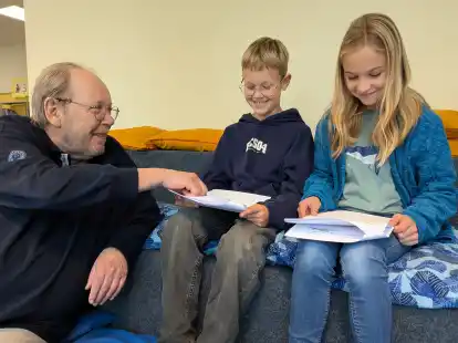 Alfred Büngen mit den Kindern Emil Rupschus und Josephine Falk. Sämtliche Schüler der Grundschule Abbehausen haben Texte für ein Buch über ihr Heimatdorf beigesteuert.