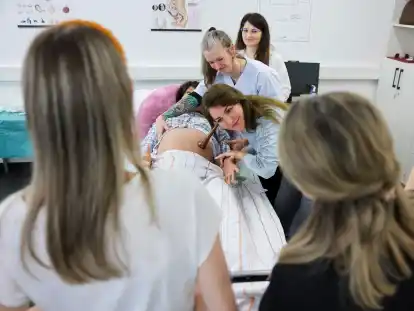 Nasrin Hashemi aus dem Iran h&ouml;rt unter Anleitung von Ausbilderin Esther Cyrus (M) die Herzfrequenz eines Ungeborenen an einer schwangeren &Uuml;bungspuppe am Institut f&uuml;r Hebammenwissenschaft ab. F&uuml;nf Frauen aus der Ukraine, Serbien, Kosovo und dem Iran absolvieren einen neuen Anpassungslehrgang f&uuml;r Hebammen aus Drittstaaten an der Universit&auml;t Leipzig. Das Pilotprojekt soll Hebammen aus Drittstaaten helfen, ihre Ausbildung in Deutschland anerkennen zu lassen.