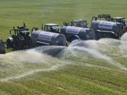 Bauernprotest: Schlepper versprühen tausende Liter Milch auf einem Feld in Ostfriesland